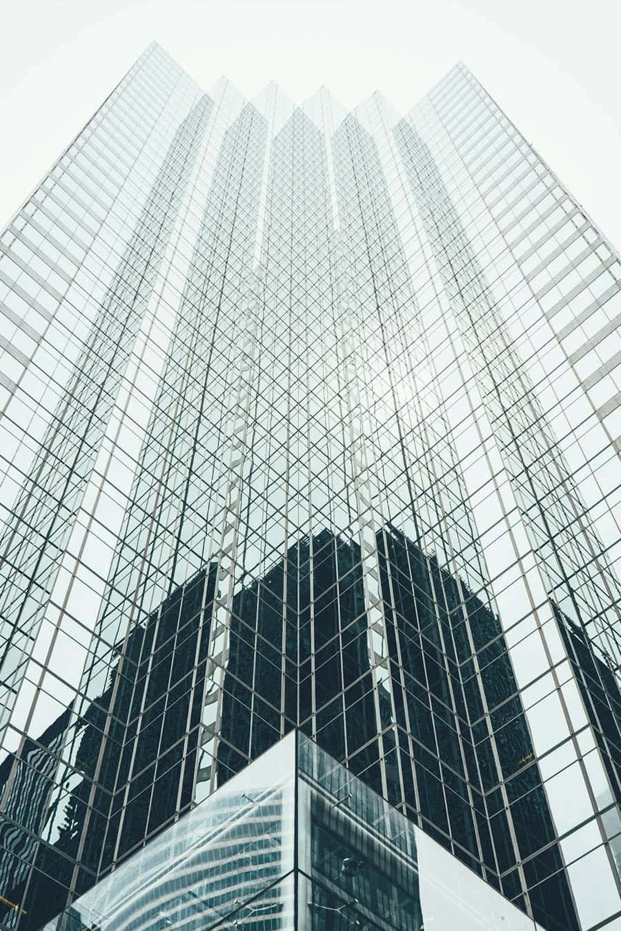 Edificio moderno de vidrio con reflejos urbanos.